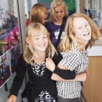Mischievous schoolgirls leaving classroom